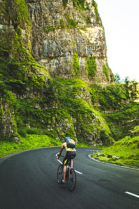 man riding on bike near brown rock formation thumbnail