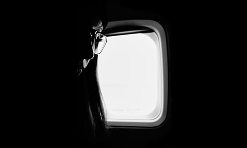 grayscale photography of woman near window thumbnail