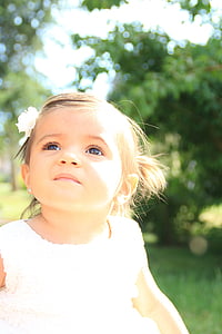 girl in white dress smiles on selective focus photo thumbnail