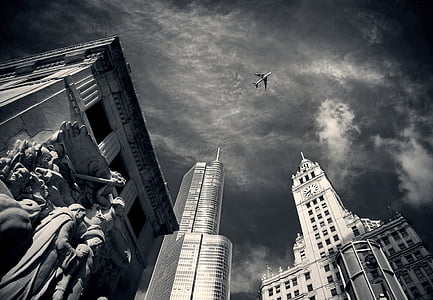 high-rise building over viewing flying airplane low-angle photography thumbnail