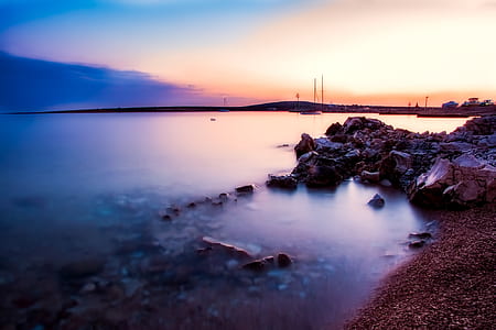 calm body of water near shore during golden hour thumbnail