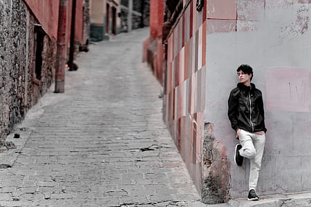 man leaning on gray concrete surface thumbnail