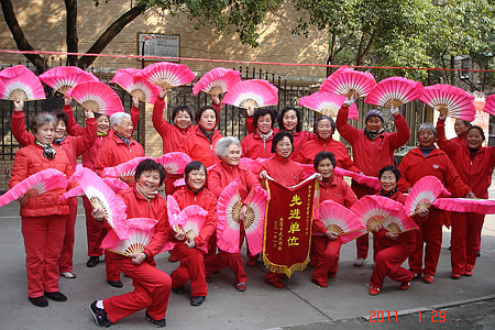 group of people wearing red traditional costume holding hand fan thumbnail