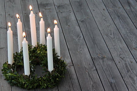 seven white candle sticks on green wreath thumbnail