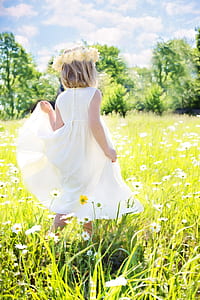 girl in white dress standing on flower field thumbnail