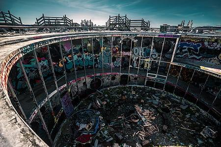 round gray concrete building with graffiti under blue sky thumbnail