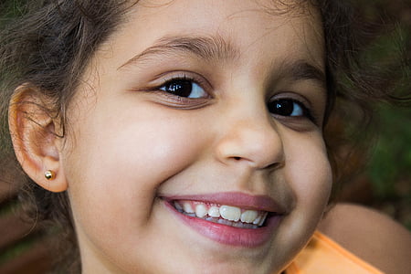 smiling girl wearing orange top thumbnail