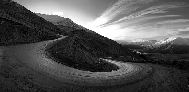 grayscale photography of empty dirt road near mountain thumbnail