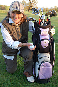 woman holding black and purple golf bag and white golf balls thumbnail