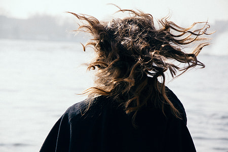 woman standing, wearing black jacket beside of seashore thumbnail