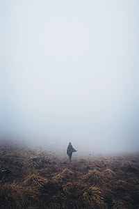 person in the distance standing on grass field thumbnail