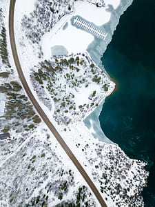 aerial photography of road near body of water covered with snow thumbnail