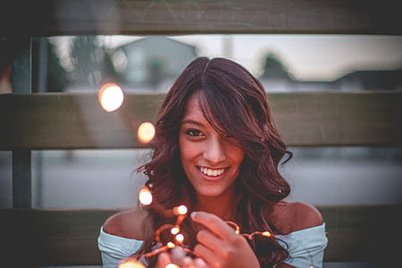 Selective Focus Photography Of Woman Holding String Lights thumbnail