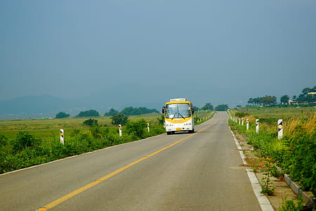 white and yellow passenger bus on road during daytime thumbnail