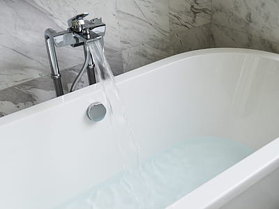 white ceramic bath tub with stainless steel faucet during daytime thumbnail