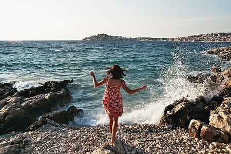 woman wearing red spaghetti strap dress in front of blue body of water thumbnail
