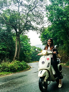 Woman Wearing White Crew-neck Shirt on Motor Scooter thumbnail