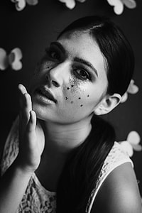 grayscale photo of woman in white sleeveless top with face paint thumbnail