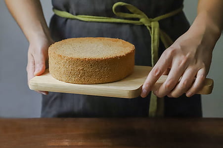 Person Holding Chopping Board With Sponge Cake thumbnail