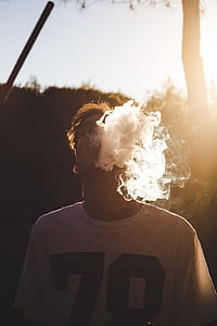 tilt-shift photography of smoking man outdoors thumbnail