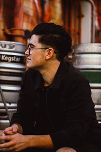 selective focus photography of man wearing black jacket and eyeglasses thumbnail