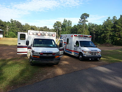 two white ambulance vehicles parked near green trees at daytime thumbnail