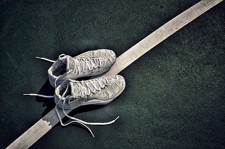 unlaced gray-and-white basketball shoes on black and white surface thumbnail