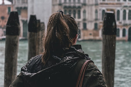 woman carrying bag in front of body of water thumbnail