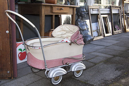 gray and pink pram stroller beside brown wooden door thumbnail