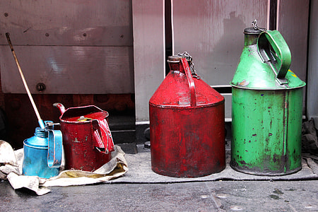 four assorted-color gas cans near gray wall thumbnail