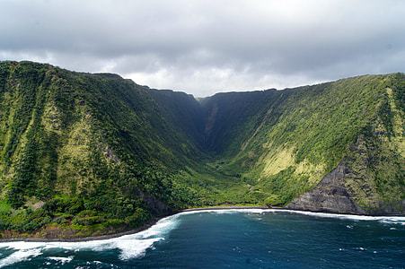aerial photo of mountain in front of body of water thumbnail