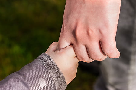 person holding child's hand thumbnail