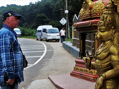 man standing near Hanuman statue thumbnail