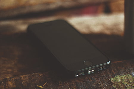 space gray iPhone 6 with black screen on brown wooden surface thumbnail