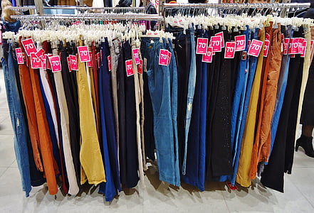 assorted denim jeans on gray metal rack thumbnail
