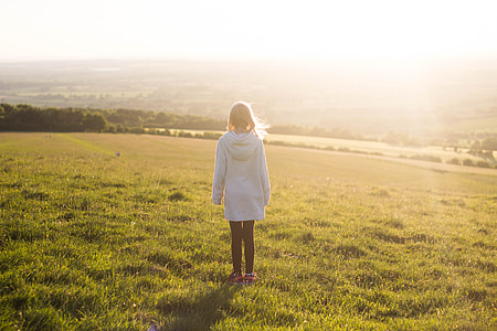 woman standing in green fields during day time thumbnail