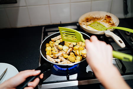 person holding plastic spatula cooking vegetables thumbnail