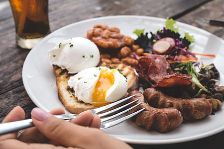 Eating high protein brunch with poached eggs, beans and bacon thumbnail