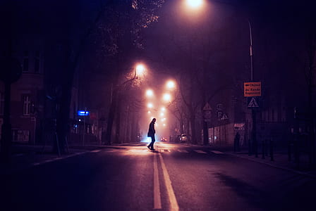 silhouette of man crossing on pedestrian lane during nighttime thumbnail