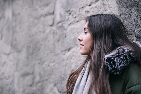 woman wearing green and black coat looking side view thumbnail