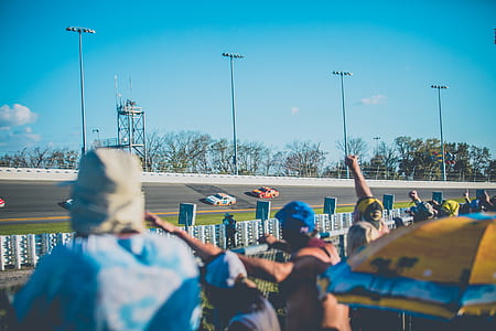 group of people watching stock car racing thumbnail