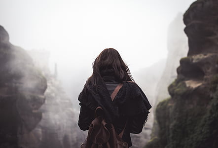 woman in black dress facing rock mountains thumbnail