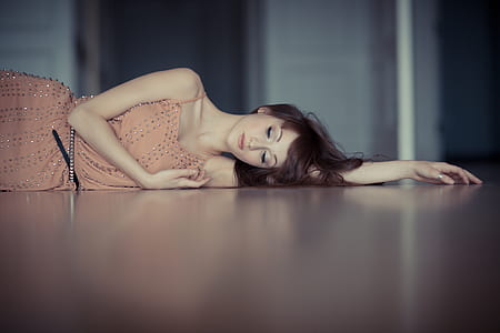 woman wearing brown dress lying on brown floor thumbnail