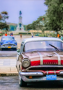 classic red car near people and trees thumbnail