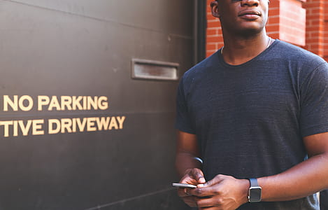 man in black t-shirt holding his smartphone thumbnail