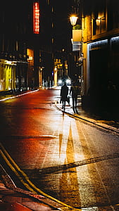 silhouette of person walking along the sidewalk during nighttime thumbnail