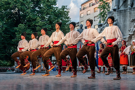seven men dancing near black statue during daytime thumbnail