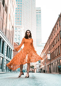 photography of woman standing in the middle of street with building s thumbnail