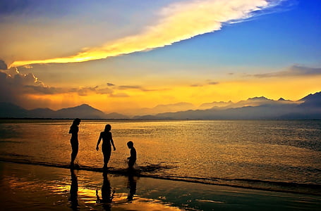 silhouette of three person walking on beach shore during sunset thumbnail