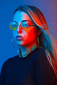 woman in black top wearing eyeglasses with blue background thumbnail